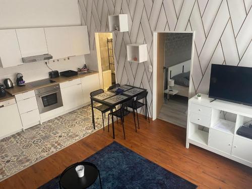 a kitchen with a table and a television in a room at Víztorony Apartmanok Siófok in Siófok