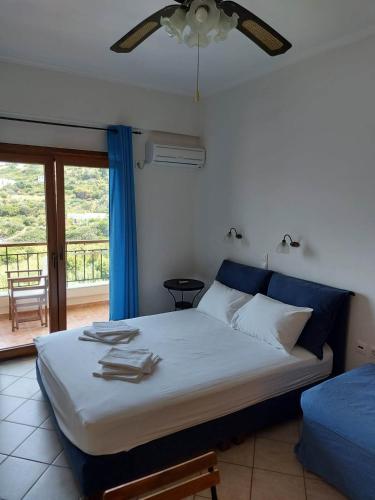 a bedroom with a bed and a window with a view at Anarrousa Studios & Apartments in Evdilos