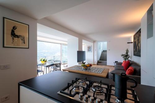 eine Küche mit einem Herd Top-Backofen neben einem Wohnzimmer in der Unterkunft REVO Apartaments - Gualzi63 the Best View in Sondrio
