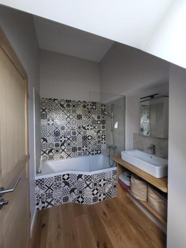 a bathroom with a tub and a sink at Manoir de La Garaye - Suite Parentale in Taden