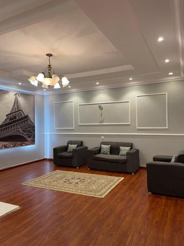 a living room with couches and a painting of the eiffel tower at غرفة وصالة في أبها in Abha