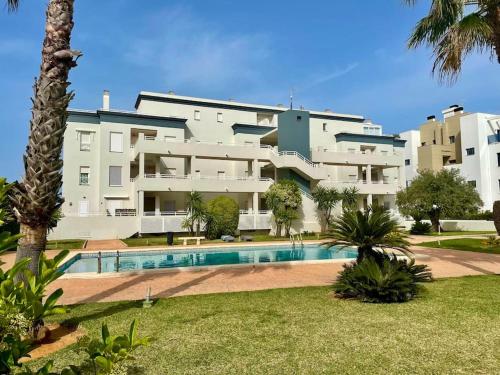 オリーバにあるOliva Nova Golf, Met & Beachの正面にプールがある大きな白い建物