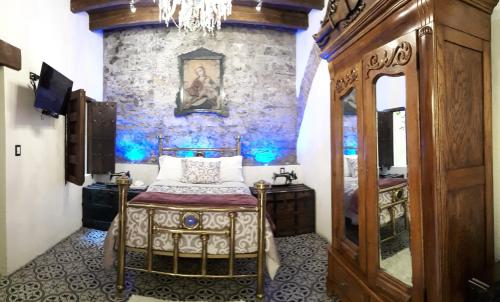 a bedroom with a bed and a stone wall at Hotel Boutique Posada XVII in Puebla
