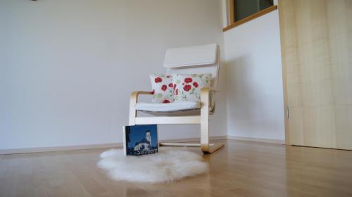 a book sitting next to a rocking chair in a room at Antoniushof in Sulzberg