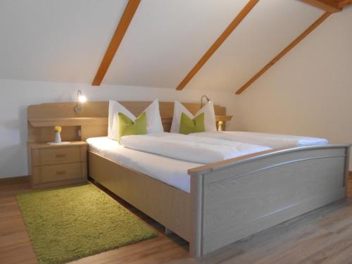 una camera da letto con un grande letto con cuscini verdi di Antoniushof a Sulzberg