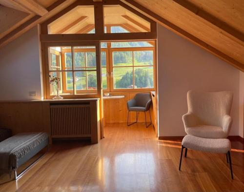 a living room with two chairs and a window at Apartment Cesa Collina Superior in Ortisei