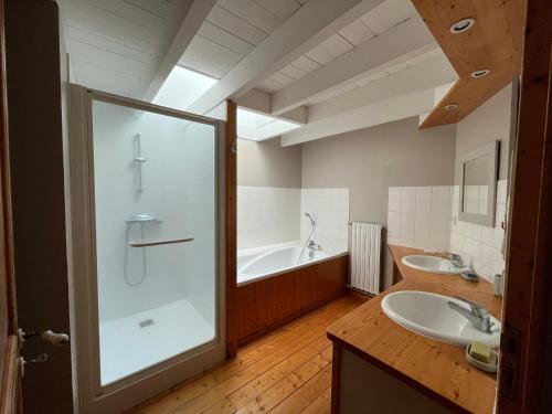 a bathroom with two sinks and a shower and a tub at Chambres de charme avec jardin et piscine in Coulonges-sur-lʼAutize