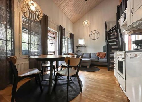 Il comprend une cuisine et un salon avec une table et des chaises. dans l'établissement Yläkerran asunto parvekkeella ja saunalla, à Tahkovuori