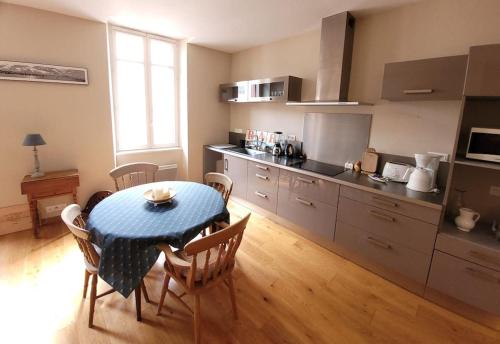 une cuisine avec une table et des chaises dans une pièce dans l'établissement Le Saint-Christophe - Les Gîtes de la Côte d'Amour, au Croisic