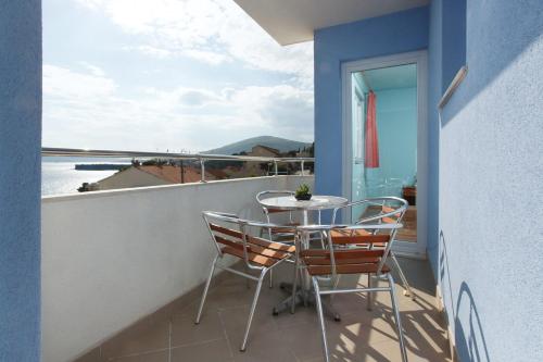 uma varanda com mesa e cadeiras e vista para o oceano em Fifty one em Trogir