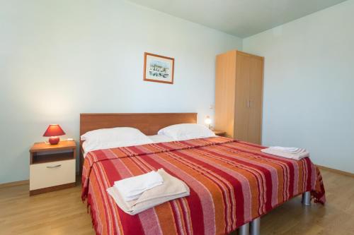 um quarto com uma cama grande e um cobertor listrado em Fifty one em Trogir