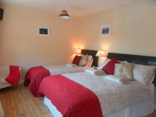 a bedroom with two beds with red and white sheets at Lettermore Country Home in Rathdrum
