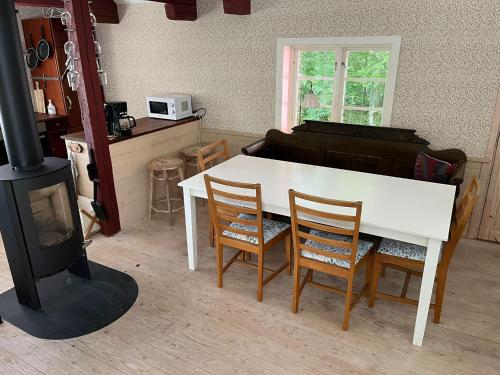 a living room with a white table and a piano at Blueberry Hill in Skånes Fagerhult