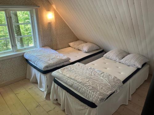 a room with two beds and a window at Blueberry Hill in Skånes Fagerhult