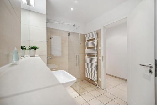 a white bathroom with a sink and a shower at NEW STUDIO@Baroque City Center in Dresden
