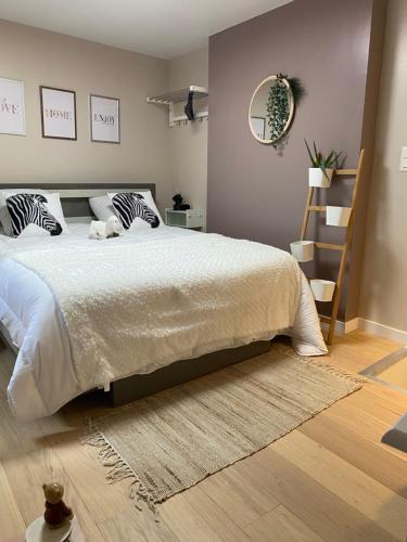 a bedroom with a large white bed with a rug at Petite maison hyper centre de Dieppe proche plage in Dieppe