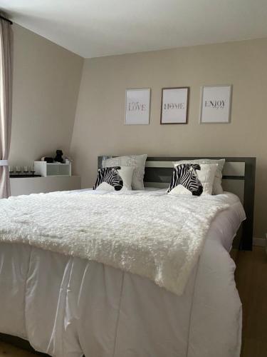 a bedroom with a large bed with white sheets and pillows at Petite maison hyper centre de Dieppe proche plage in Dieppe