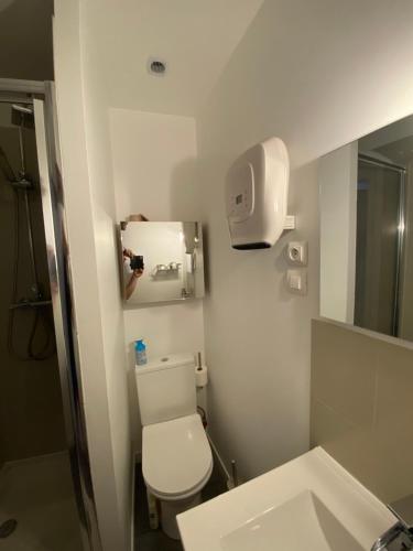 a white bathroom with a toilet and a sink at Petite maison hyper centre de Dieppe proche plage in Dieppe