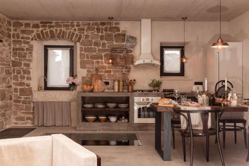 a kitchen with a table and a brick wall at She House - built for pleasure - Island of Brač in Gornji Humac
