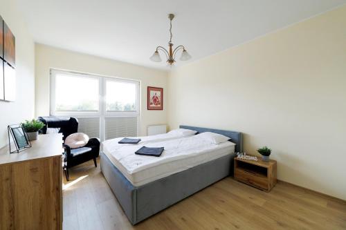 a bedroom with a bed and a desk and a chair at Apartament Marinus ProstyWynajem Gdańsk Brzeźno in Gdańsk