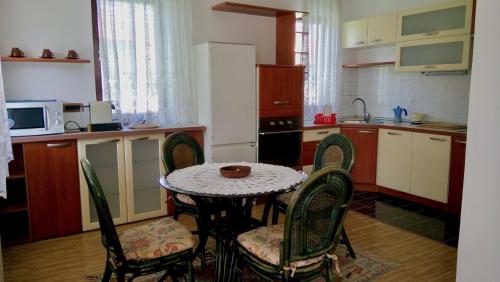 kuchnia ze stołem i krzesłami oraz kuchnia z kuchenką mikrofalową w obiekcie Villa Nora Garden w Sarajewie