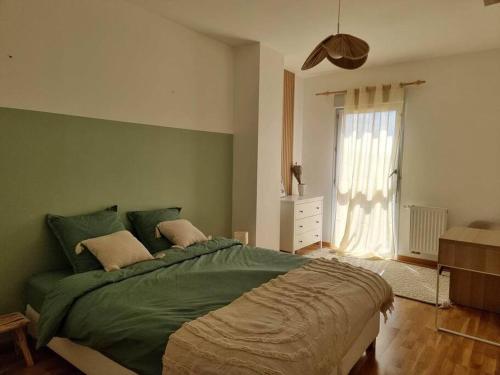 - une chambre avec un lit vert et une fenêtre dans l'établissement Chez Sara et Joan : T2 hypercentre, cosy proximité gare, à Orléans