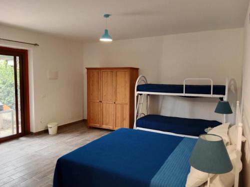 a bedroom with a blue bed and bunk beds at Brezza Marina Studios in Montesilvano