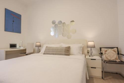 sypialnia z białym łóżkiem i krzesłem w obiekcie FIORINA w mieście Saronno