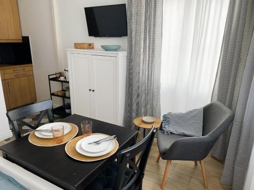 Un comedor con mesa y sillas y un televisor. en SOPOT A 200 m do plaży, en Sopot