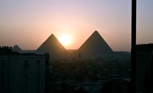 a view of the pyramids of giza at sunset at Jessy Pyramids View Inn in Cairo