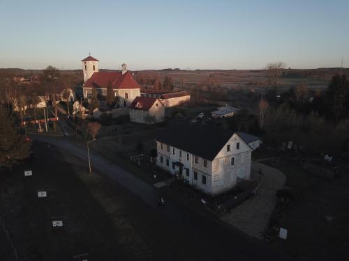 - une vue aérienne sur une grande maison blanche et une église dans l'établissement Dom Mili, à Henryków Lubański