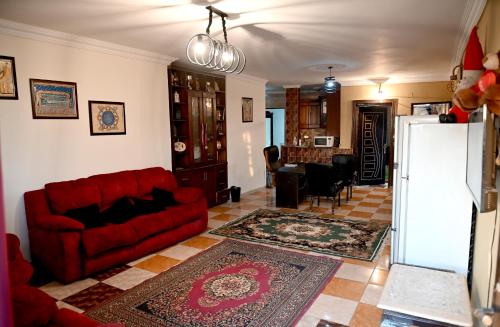 a living room with a red couch and a kitchen at Jessy Pyramids View Inn in Cairo
