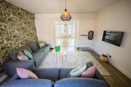 a living room with a blue couch and a tv at Elegant 2 Bedroom Apartment 75m2 - SD23G in Eindhoven