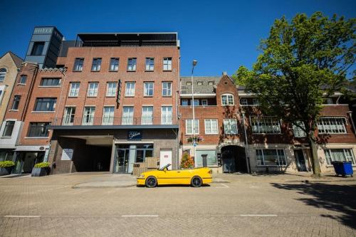 a yellow car parked in front of a building at Elegant 2 Bedroom Apartment 75m2 - SD23G in Eindhoven