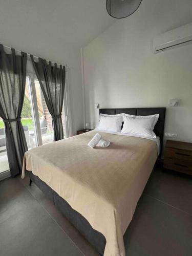 a bedroom with a large bed with a large window at •Naiades Villas• Odysseus• in Ladharió