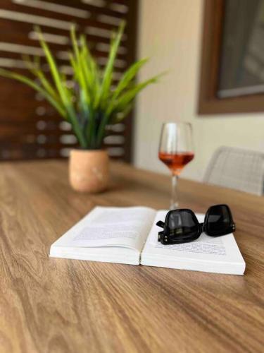 a book and glasses on a table with a glass of wine at •Naiades Villas• Odysseus• in Ladharió