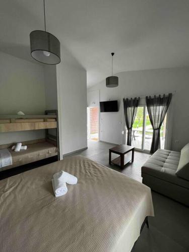a bedroom with a large bed and a couch at •Naiades Villas• Odysseus• in Ladharió