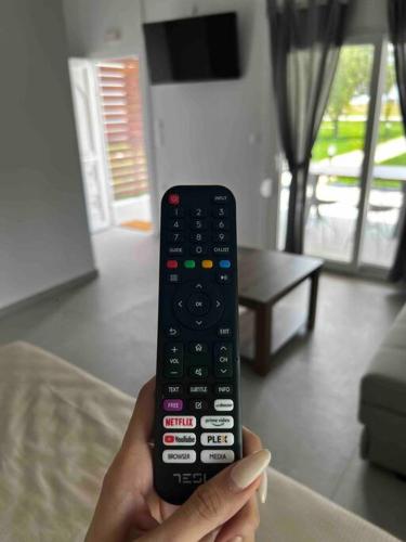 a person holding a remote control in a living room at •Naiades Villas• Odysseus• in Ladharió