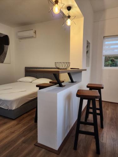 a bedroom with a bed and a table and two stools at Apartmani Radman in Igalo