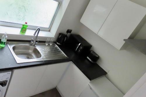 a small kitchen with a sink and a window at The King Stay in Manchester