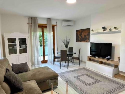 a living room with a couch and a tv and a table at Appartamento Luminoso Domus EUR in Rome