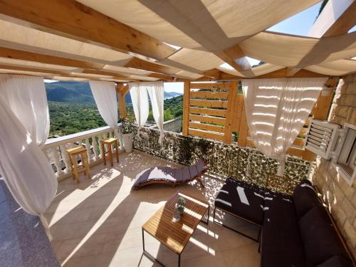 a living room with a table and chairs and windows at Holiday Home Peran in Grebaštica