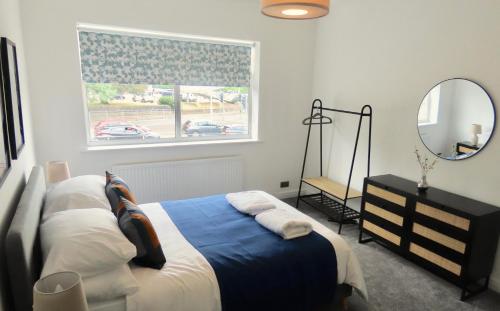 1 dormitorio con cama y ventana con espejo en The King Stay, en Mánchester