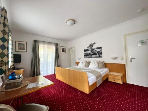 a hotel room with a bed and a desk at LANDHAUS luise in Bad Reichenhall