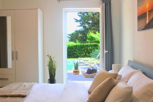 a bedroom with a bed and a door to a patio at Villa Fjaka in Umag