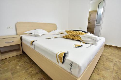 a bed with white sheets and gold decorations on it at Casa Ryn in Vama Veche