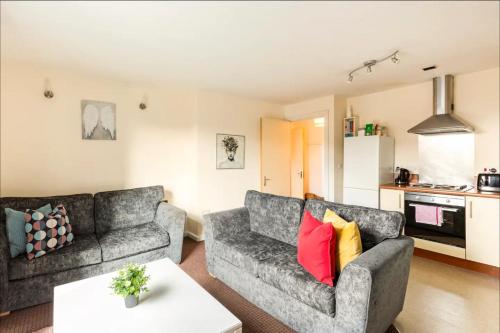a living room with two couches and a kitchen at Mosh Aparthotel Salford in Manchester