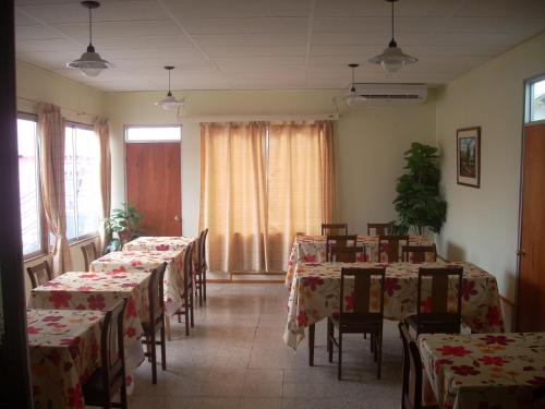 a dining room with tables and chairs with red table cloth at Hostal Casa Kolping in Arica