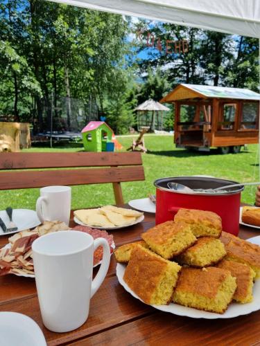 einen Tisch mit einem Teller Brot und Kaffeetassen in der Unterkunft Ethno Village Koljeno Camp & Bungalows in Andrijevica