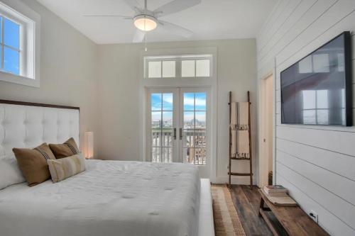 a white bedroom with a large bed and a window at Luxury townhome, steps to beach and resort fun! in Port Aransas